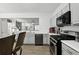 Kitchen with gray cabinets and stainless steel appliances and view of the living area at 10900 Wittenridge Dr # I4, Alpharetta, GA 30022