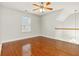 Bedroom featuring hardwood floors, a window, and access to the staircase at 113 Highgrove Pl, Mcdonough, GA 30253