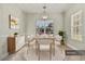 Dining room area showcases elegant decor, with a wooden table, white chairs, and a stylish cabinet at 113 Highgrove Pl, Mcdonough, GA 30253