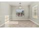 Empty dining room space featuring neutral walls, tile floors, and large windows, providing natural light at 113 Highgrove Pl, Mcdonough, GA 30253