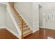 Inviting foyer featuring hardwood floors, a staircase with wooden banister, and a front door with glass accents at 113 Highgrove Pl, Mcdonough, GA 30253
