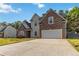 Appealing two-story home with stone accents, a two-car garage, and a large driveway at 113 Highgrove Pl, Mcdonough, GA 30253