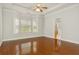 Main bedroom with gleaming hardwood floors, a tray ceiling, and a view of the ensuite bathroom at 113 Highgrove Pl, Mcdonough, GA 30253