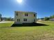 Large, green backyard features a lawn and two-story home, offering a serene outdoor space at 205 Sullivan St, Hampton, GA 30228