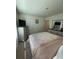Well-lit bedroom featuring a soft pink comforter, TV, and light-colored furniture at 205 Sullivan St, Hampton, GA 30228