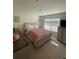 Well-lit bedroom featuring a soft pink comforter and light-colored furniture at 205 Sullivan St, Hampton, GA 30228
