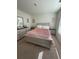 Well-lit bedroom featuring a soft pink comforter and light-colored furniture at 205 Sullivan St, Hampton, GA 30228