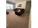 Spacious living room featuring a comfortable large brown sectional sofa and a bright window at 205 Sullivan St, Hampton, GA 30228
