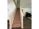 Carpeted staircase with white banister leads to an open living area with hardwood floors and natural light at 205 Sullivan St, Hampton, GA 30228