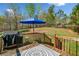 Back deck with a grill and umbrella with seating overlooking the backyard at 33 Blue Springs Way, Dallas, GA 30157