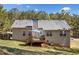 Rear exterior view of the home with a deck, fenced yard, and mature trees at 33 Blue Springs Way, Dallas, GA 30157