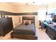 Modern bedroom with a large bed, dark wood dresser, and dedicated workstation at 4881 Belle Estates Rd, Suwanee, GA 30024
