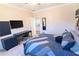Bedroom with a blue color scheme, featuring a desk, wall-mounted TV, and patterned bedding at 4881 Belle Estates Rd, Suwanee, GA 30024