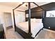 Spacious bedroom showcasing a four-poster bed, dark accent wall, and neutral carpet at 4881 Belle Estates Rd, Suwanee, GA 30024