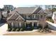 Beautiful two-story brick home featuring a well-manicured lawn and inviting front porch area at 4881 Belle Estates Rd, Suwanee, GA 30024