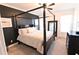 Stylish bedroom with a dark four-poster bed, dark accent wall, and bright natural light at 4881 Belle Estates Rd, Suwanee, GA 30024