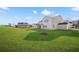 Large back yard of this home on a sunny day with other homes visible nearby at 5130 Travers Ln, Cumming, GA 30040