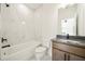 Modern bathroom featuring granite counters, white tub, black fixtures, and marble-look tile at 5130 Travers Ln, Cumming, GA 30040