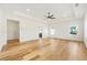 Bright and airy bedroom featuring hardwood floors, a ceiling fan, and ample natural light at 5130 Travers Ln, Cumming, GA 30040