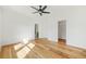 Spacious bedroom features hardwood floors, a ceiling fan, and access to closet and bathroom at 5130 Travers Ln, Cumming, GA 30040