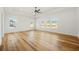 Spacious bedroom with hardwood floors, tray ceiling, ceiling fan, and plenty of natural light from large windows at 5130 Travers Ln, Cumming, GA 30040