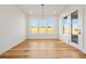 Bright dining room featuring hardwood floors, white walls, ample natural light, and modern light fixture at 5130 Travers Ln, Cumming, GA 30040