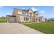 Two-story home featuring a brick facade, a two-car garage, and a well-manicured lawn at 5130 Travers Ln, Cumming, GA 30040