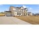 Two-story home featuring a brick facade, a two-car garage, and a well-manicured lawn at 5130 Travers Ln, Cumming, GA 30040