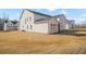 View of the exterior of a new construction home with white brick, neutral siding, and a view of neighboring properties at 5130 Travers Ln, Cumming, GA 30040
