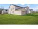 View of the exterior of a new construction home with white brick, neutral siding, and a spacious backyard at 5130 Travers Ln, Cumming, GA 30040