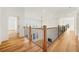 Open hallway featuring beautiful hardwood floors, staircase view, and lots of natural light at 5130 Travers Ln, Cumming, GA 30040