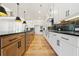 Modern kitchen featuring an island with bar seating, stainless steel appliances, and wood floors at 5130 Travers Ln, Cumming, GA 30040