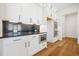 Modern kitchen featuring white cabinets, stainless steel appliances, and a black countertop at 5130 Travers Ln, Cumming, GA 30040
