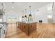 Open-concept kitchen with stainless steel appliances, an island with seating, and hardwood floors at 5130 Travers Ln, Cumming, GA 30040