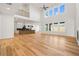 Bright open living room with hardwood floors, high ceilings, and a view of the kitchen at 5130 Travers Ln, Cumming, GA 30040