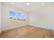 Unfurnished room with hardwood floors and three windows overlooking the yard at 5130 Travers Ln, Cumming, GA 30040