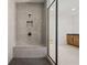 Stylish shower with gray tiling, a built-in bench, and matte black fixtures at 5130 Travers Ln, Cumming, GA 30040