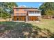 Backyard view showcasing a brick home with a deck, screened in porch and spacious yard at 1085 Crown River Pkwy, Mcdonough, GA 30252