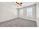Bedroom showcasing two bright windows, soft carpet, neutral walls, and modern ceiling fan at 1085 Crown River Pkwy, Mcdonough, GA 30252