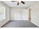 Bedroom with plush carpet, neutral walls, a ceiling fan and a large window with a view of outdoors at 1085 Crown River Pkwy, Mcdonough, GA 30252