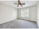 Bedroom features a window, fan, and neutral carpet and walls creating a cozy atmosphere at 1085 Crown River Pkwy, Mcdonough, GA 30252