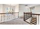 Hallway with decorative metal railing, chandelier, and a view of outdoors through a large arched window at 1085 Crown River Pkwy, Mcdonough, GA 30252