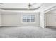 Generous main bedroom featuring window, door to ensuite and ceiling fan at 1085 Crown River Pkwy, Mcdonough, GA 30252