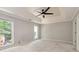Bedroom with a ceiling fan, tray ceiling, and view of the backyard through two windows at 2648 Kenwood Dr, Duluth, GA 30096