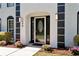 Close up of front door with decorative glass, surrounded by manicured landscaping and black trim at 2648 Kenwood Dr, Duluth, GA 30096