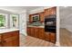 Kitchen view of the oven wall and breakfast nook featuring an island, dark cabinets, and tiled backsplash at 2648 Kenwood Dr, Duluth, GA 30096