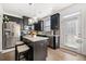 Well-lit kitchen with black cabinetry, stainless steel appliances, and island with granite countertop at 2709 Kemp Court, Conyers, GA 30094