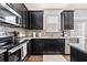 Kitchen featuring black cabinetry, tile backsplash, stainless steel appliances and wood floor at 2709 Kemp Court, Conyers, GA 30094