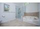 Bathroom features a glass-enclosed shower, soaking tub, and tiled flooring at 4066 Harvest Ridge Dr, Douglasville, GA 30135