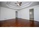 Bright bedroom featuring hardwood floors, tray ceiling, and white trim throughout at 4066 Harvest Ridge Dr, Douglasville, GA 30135